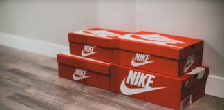 Buty Nike w kartonach na tle ściany i eleganckiej podłogi